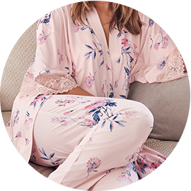 Model wearing pale pink floral pajamas and a matching kimono
